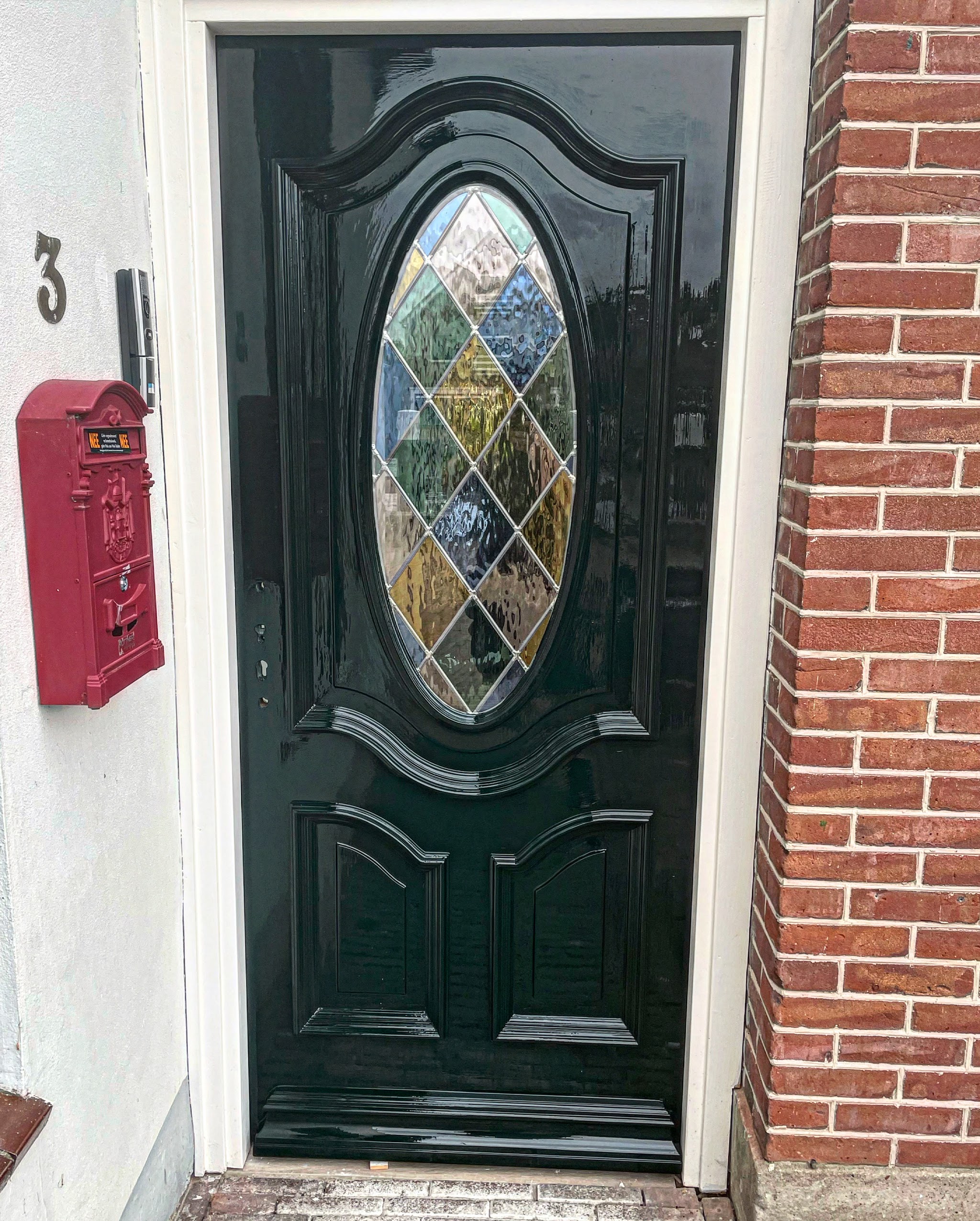 Glanzend donkergroene klassieke voordeur met ovaal glas-in-lood raam