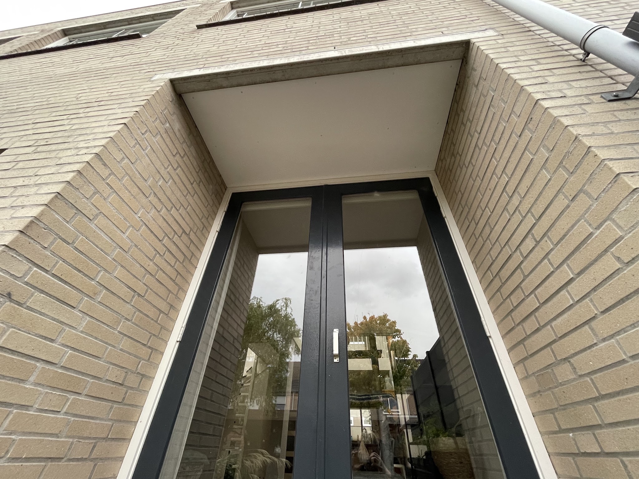 Antraciet openslaande deuren in een nis in de gevel