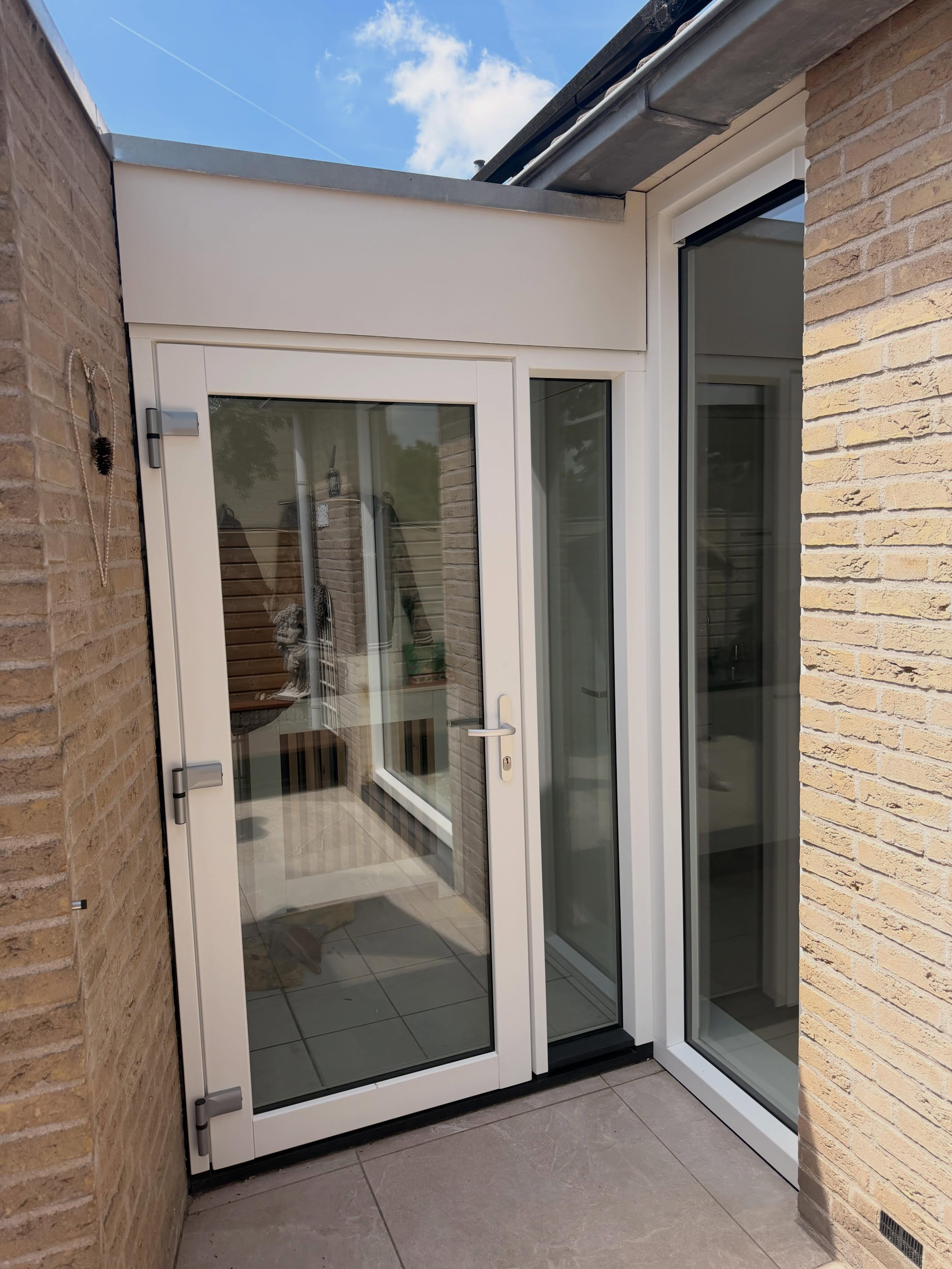Nieuwe witte deur met zijlicht in een aanbouw
